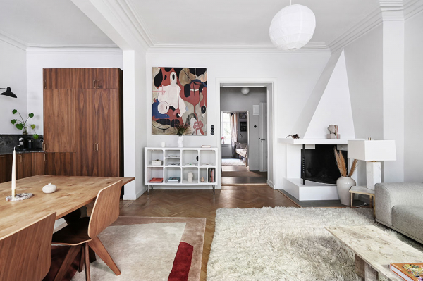 Кухня без верхних шкафчиков и камин: светлая квартира на первом этаже в Стокгольме