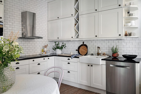 Белый интерьер шведской квартиры с душевным декором и растениями